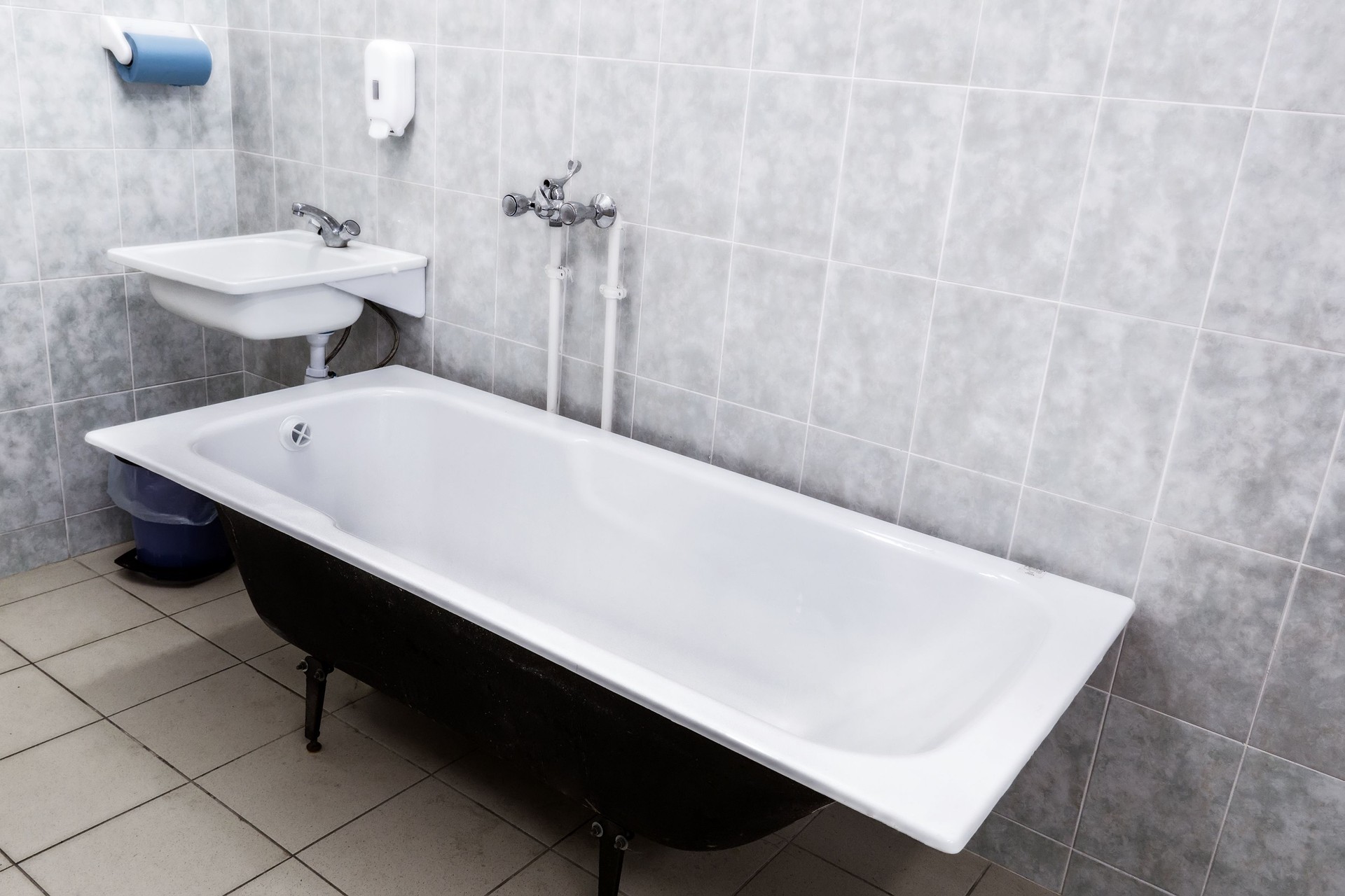 Old bathroom with sink and tiled walls. USSR