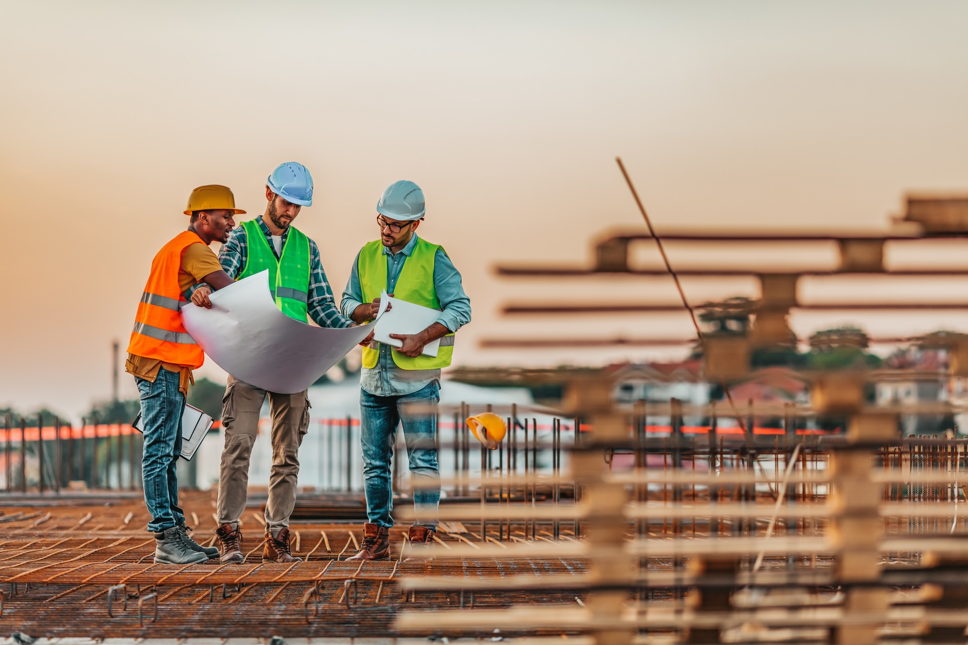 Manual workers talking with an architect while going through housing plans